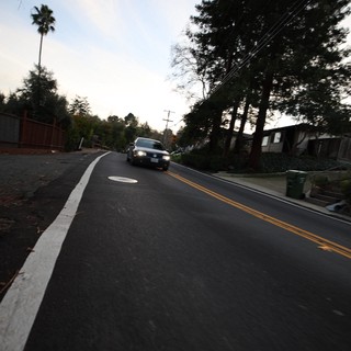 Residential Street at Dusk with Approaching Vehicle