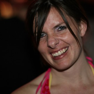 Radiant Smile of a Woman at a Nighttime Gathering