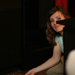 Curious Woman Peering Around Dark Furniture