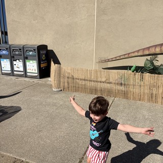 Carefree Child with Arms Outstretched in Sunny Courtyard