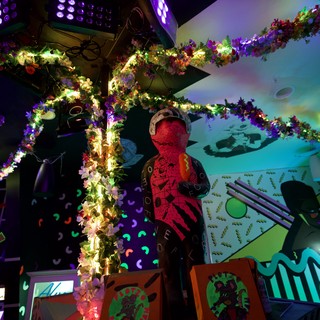 Vibrant Art Installation with Illuminated Floral Garlands and Projections