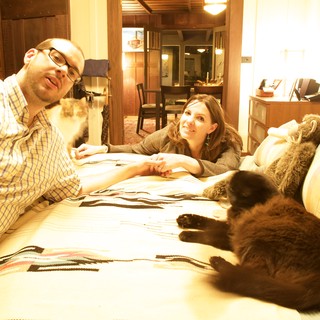 Couple Relaxing on Bed with Their Cats