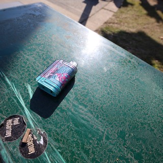 Crushed Beer Can on Worn Green Ping Pong Table
