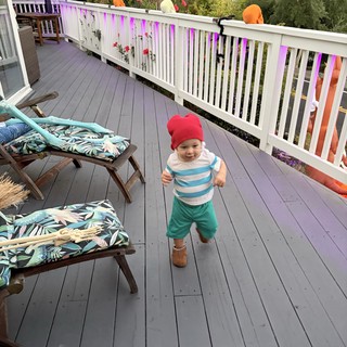 Joyful Toddler Running on Decorated Deck