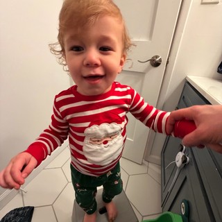 Toddler in Festive Christmas Pajamas in Bathroom