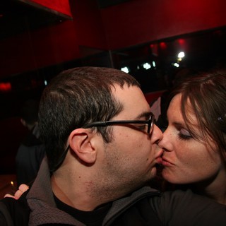 Couple Sharing a Kiss at Dimly Lit Nightclub