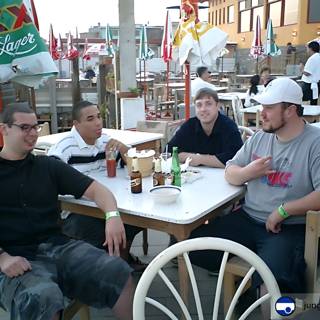 Four Men Enjoying Beer and Food at a Restaurant