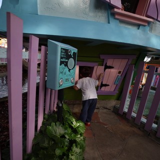 Child Exploring Interactive Installation at Whimsical Waterside Pavilion