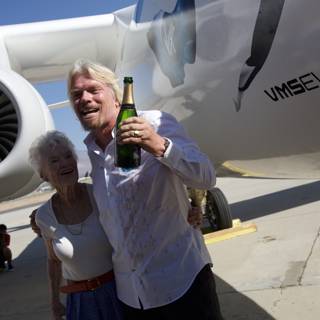 Richard Branson and companion stand next to their aircraft