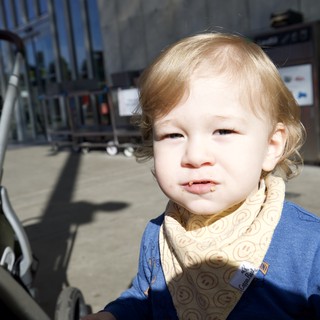 Toddler with Blonde Hair Enjoying Snack Outdoors