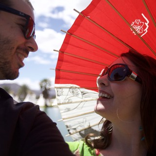Shared Laughter Under a Red Parasol at Coachella