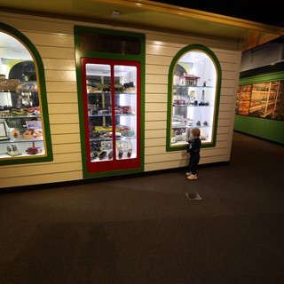 Young Visitor Explores Vintage Toy Display at Museum