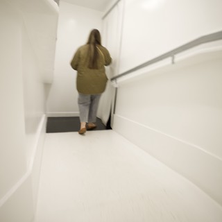 Woman Ascending White Modern Staircase in Minimalist Interior