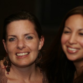Two Women Smiling at Evening Celebration Event