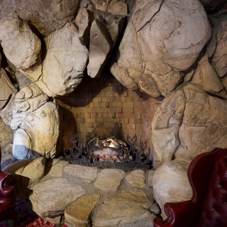 Rustic Stone Fireplace with Leather Armchairs in Cave-Like Interior