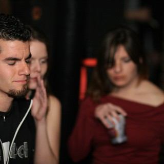 Young Man Lost in Thought at Nightclub Party