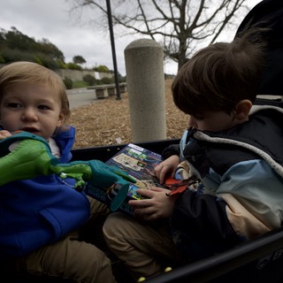 Brothers Reading Together at Playground on Winter Day