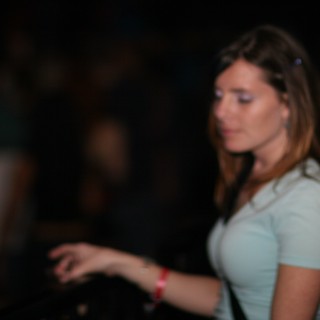 Woman in White Tee at Dimly Lit Nightclub