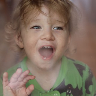 Joyful Toddler in Green Dinosaur Shirt