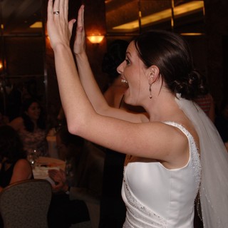 Joyful Bride High-Fives Guest at Wedding Reception