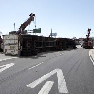 Crane lifting overturned truck on city street