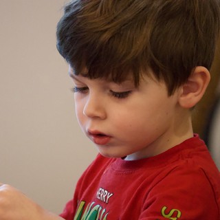 Young Boy Concentrating in Red Christmas Shirt