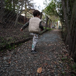 Young Child Walking Along Gravel Path in Autumn