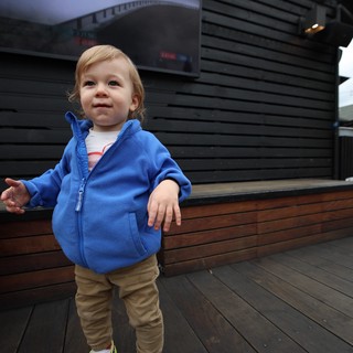 Toddler on Wooden Deck with Modern Building