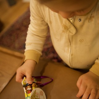 Young Child Playing with Christmas Ornament Toy