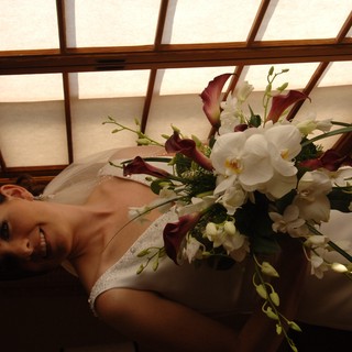 Radiant Bride with Cascading Orchid Bouquet by Window