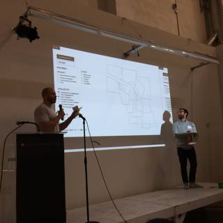 Two speakers presenting in front of a projection screen