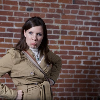 Defiant Woman Poses Against Urban Brick Wall