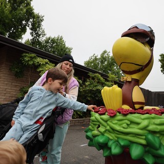 Child Touches Woodstock Statue at Theme Park