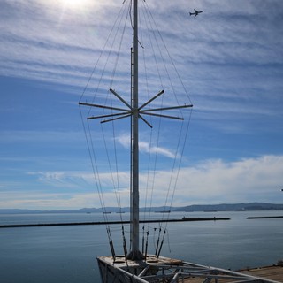 Antenna Mast Silhouette Against Bay Waters and Sky