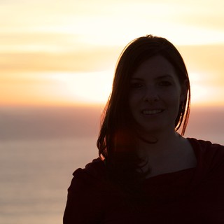 Smiling Woman Silhouetted Against Golden Sunset