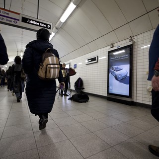 Commuter Walking Through London Underground Station Corridor