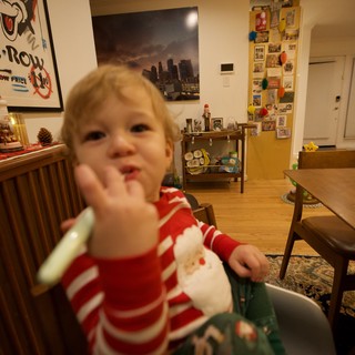 Toddler in Red Striped Pajamas Waving at Camera