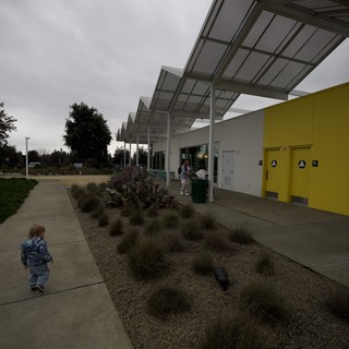 Child Walking at Modern Community Center with Solar Canopy