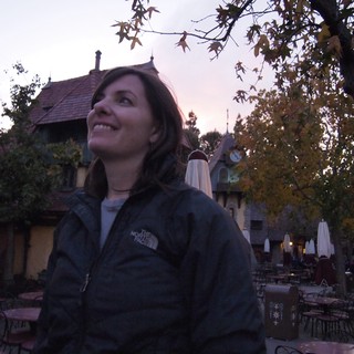 Smiling Woman at Dusk in Fairy-Tale Village Setting