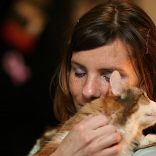 Tender Moment: Woman Nuzzles Ginger Kitten Lovingly