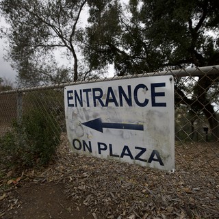 Weathered Entrance Sign Directing to Plaza