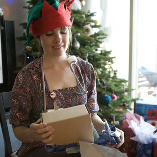 Joyful Elf Unwrapping Christmas Gifts at Home
