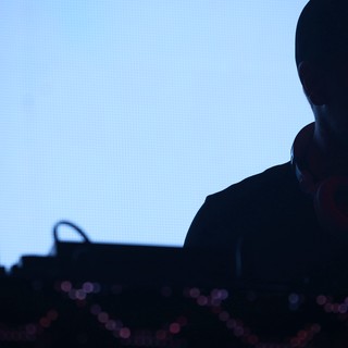 DJ Silhouette Against Blue LED Screen at Wobbleland