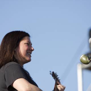 Kim Deal strums her guitar under the blue sky