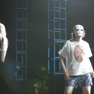 Masked Man on Stage with a Crowd