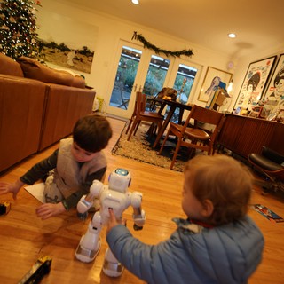 Children Playing with White Robot in Modern Living Room