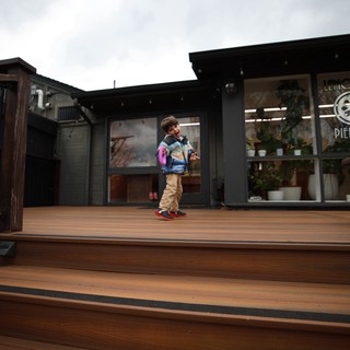 Child with Pink Backpack on Modern Wooden Deck