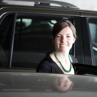 Smiling Woman Beside a Dark SUV Door