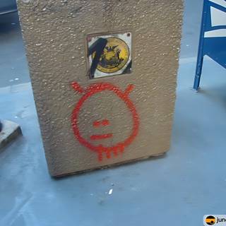 Red Sticker on Cement Box with Face