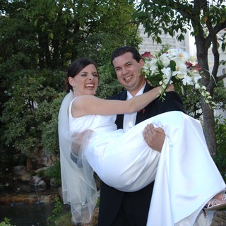 Joyful Groom Carries Laughing Bride in Garden